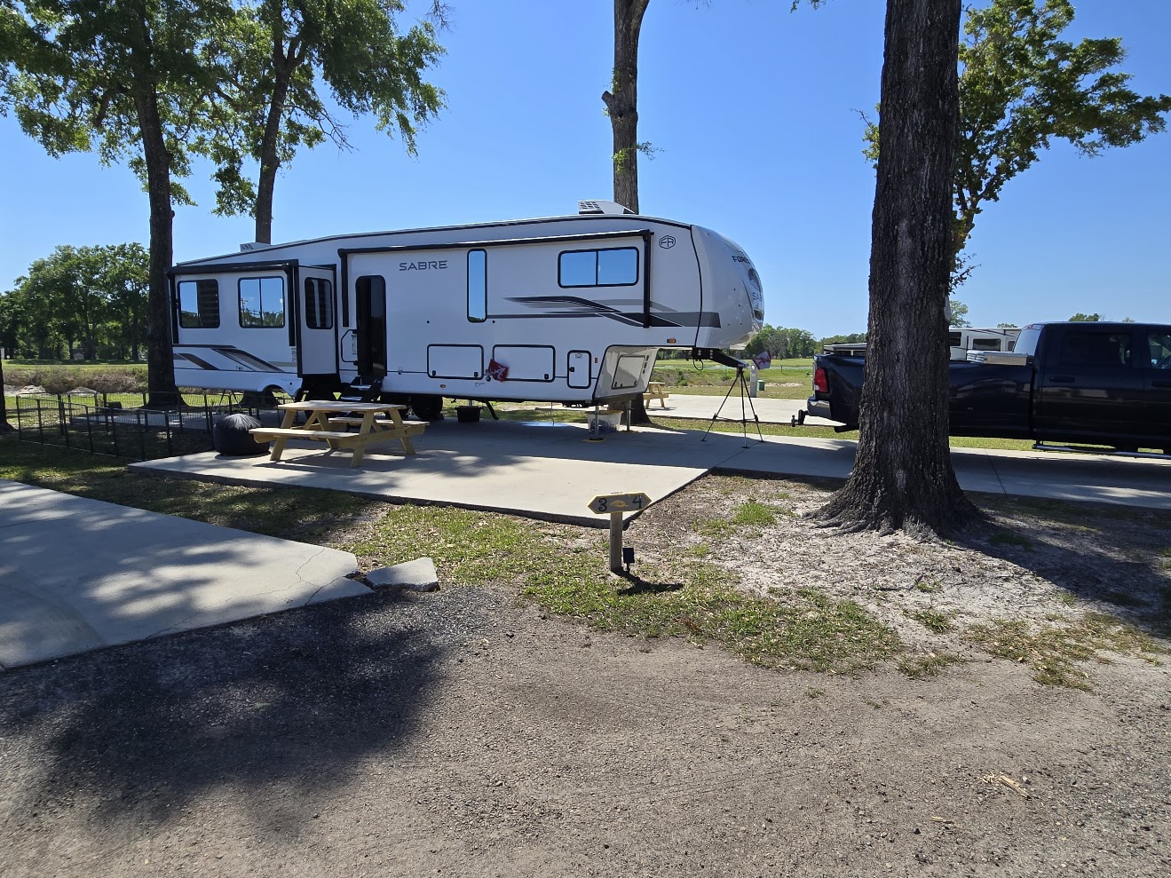 Our 5th wheel set up at a wooded campsite at dusk